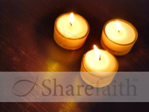 Three Lit Candles on Wood